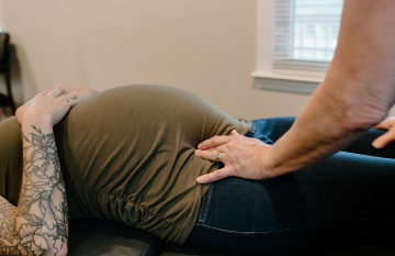 Photo of an pregnant woman receiving chiropractic treatment